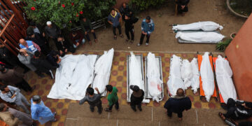 People stand near bodies of Palestinians who were killed during Israeli strikes on Ma'an school east of Khan Younis, at Nasser hospital, amid the ongoing conflict between Israel and Palestinian Islamist group Hamas, in Khan Younis in the southern Gaza Strip, December 5, 2023. REUTERS/Ibraheem Abu Mustafa