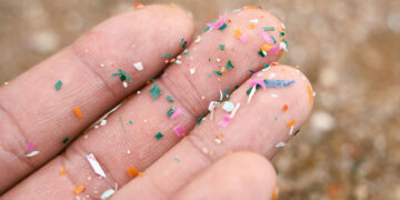 Close up side shot of microplastics lay on people hand. Concept of water pollution and global warming. Climate change idea. micro plastics concept in food and water or sea