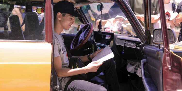 (240702) -- ALEXANDRIA, July 2, 2024 (Xinhua) -- People read books at a mobile taxi library in Alexandria, Egypt, June 29, 2024.
  TO GO WITH "Feature: Egyptian taxi driver turns cab into mobile library to encourage reading" (Xinhua/Ahmed Gomaa)